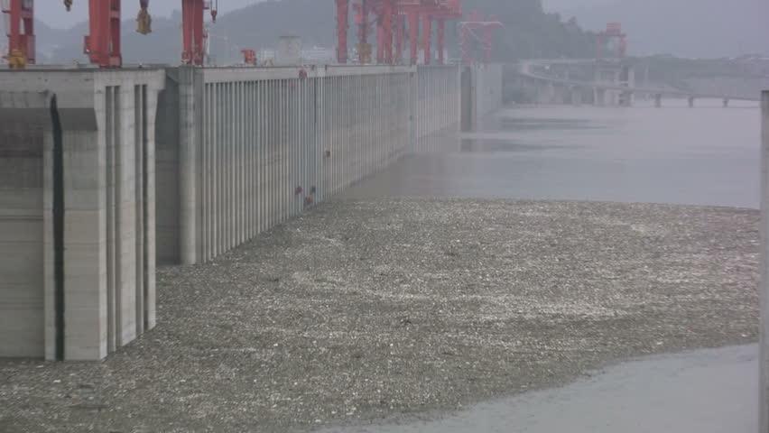 Workers are cleaning up pollution in front of the walls of the Three Gorges Dam near Sandouping, China
