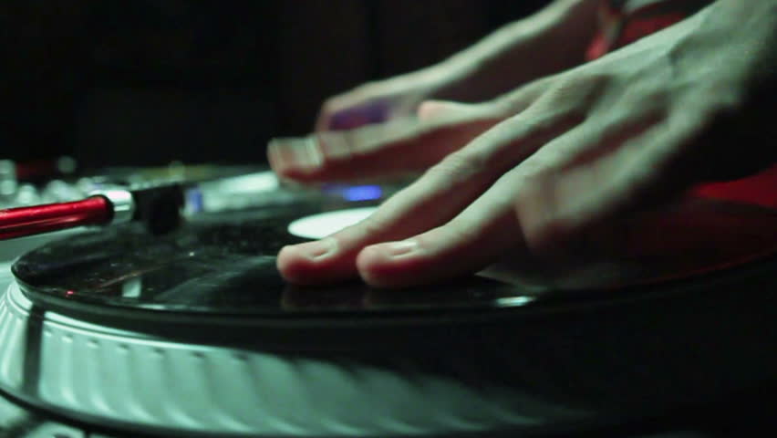  DJ scratching on the Decks at a disco / Nightclub