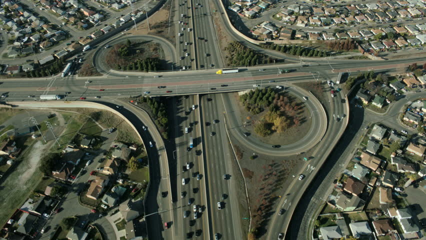 Aerial view of busy city traffic at an intersection on a major freeway in the suburbs of the city