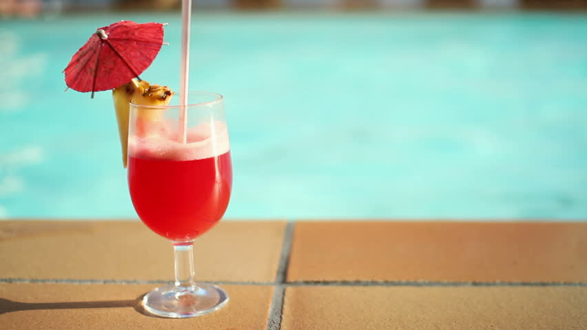 Summer drink with umbrella by the swimming pool
