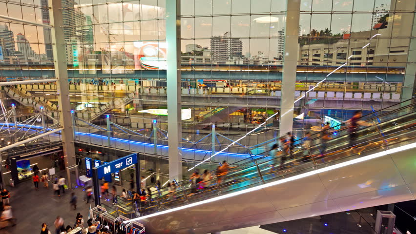 BANGKOK - MARCH 31: (Time lapse view) People taking escalators at Terminal 21 on MArch 31, 2012 in Bangkok, Thailand. The newly built mall, which opened in October, was designed to resemble an airport. Bangkok aerial subway can be seen in the background.