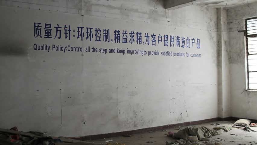 abandoned factory building with ironic quality control reminder painted on the wall