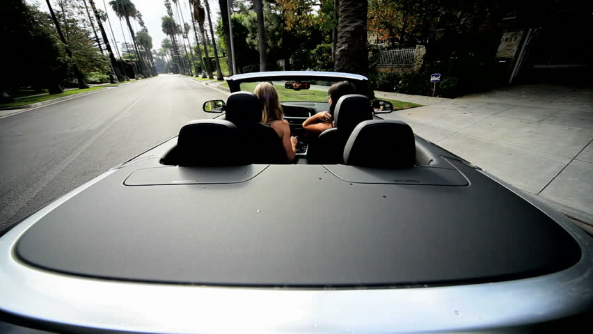 Beautiful girlfriends driving open top convertible