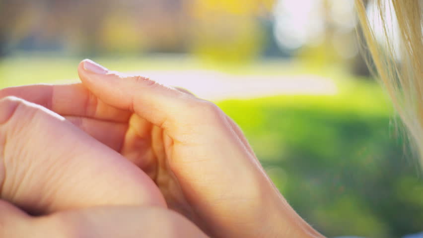 A mothers hands in close up holding the foot of her baby