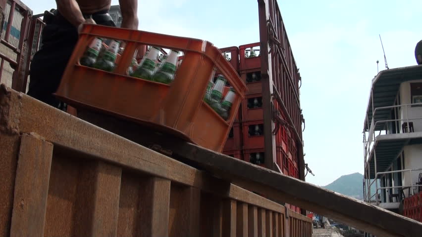 CHONGQING - 17 AUGUST: People are loading beer crates onto a cargo ship  on August 17, 2010 in Chongqing, China 