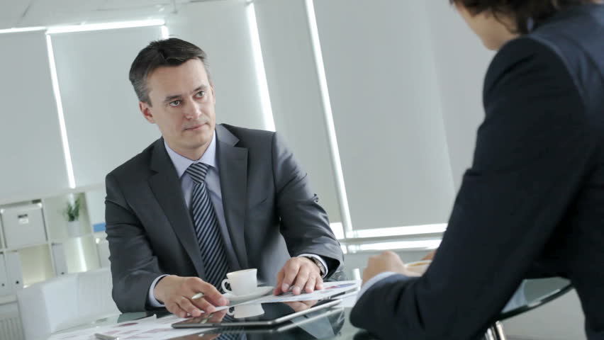 Handsome businessman telling his colleague about contemporary business issues