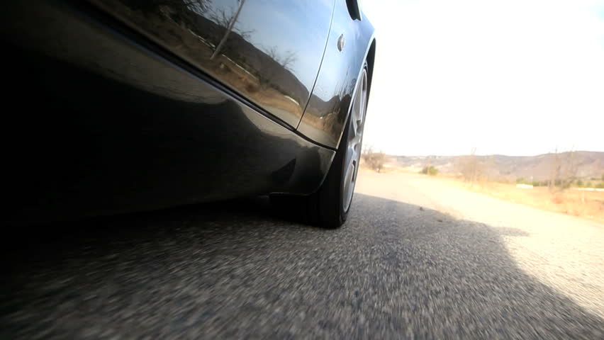 road view of car tires rotating on the road
