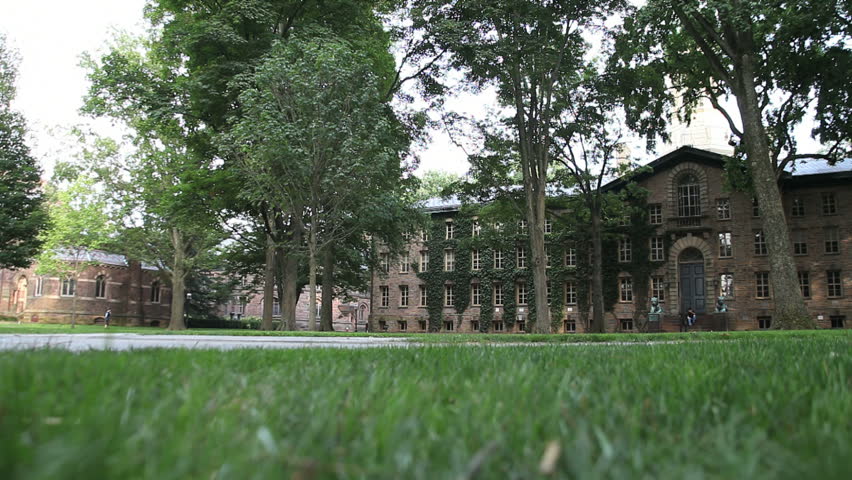 students walking down open grassy area in front of administrative buildings 