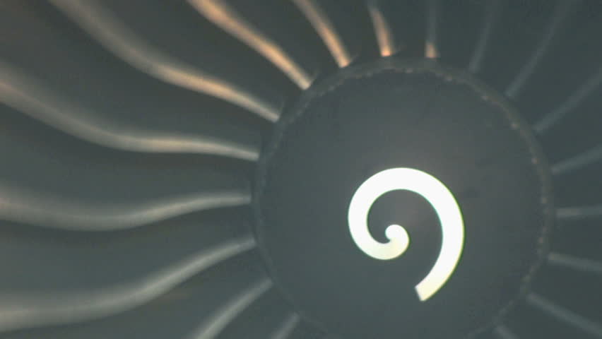 A crazy turbo jet engine spins around and around while it sits on the tarmac at the airport.