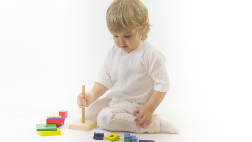 boy playing with toy in white room