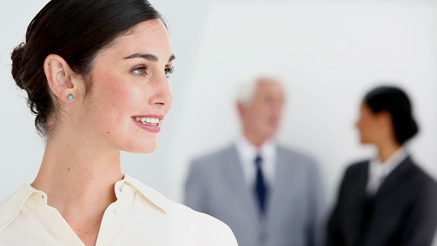 Smiling businesswoman posing with colleagues talking against white background