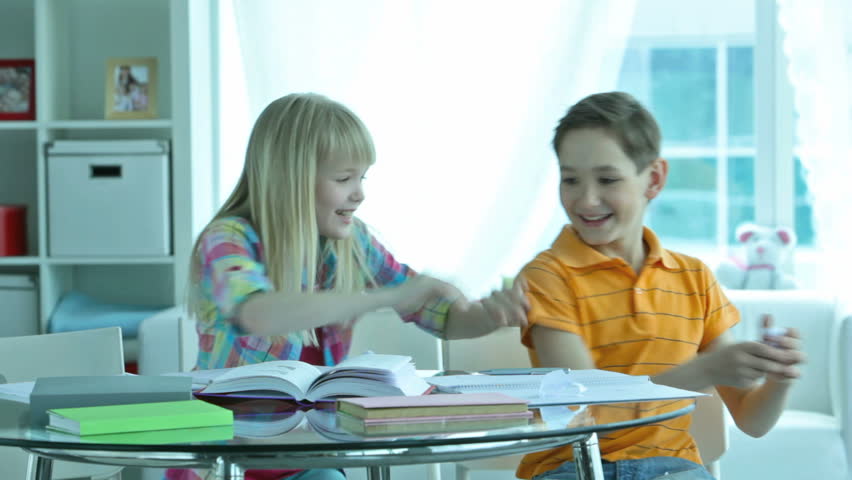 Girl trying to take a crumpled sheet of paper with some secret notice away from her friend who playfully fighting back