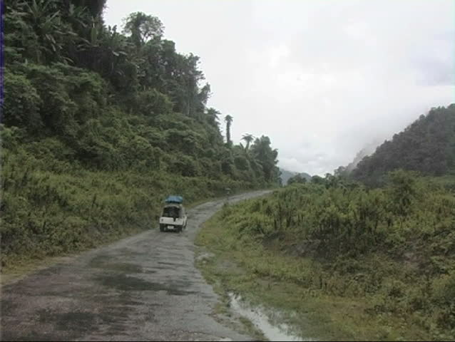 A rainy day in Arunachal Pradesh, India.  Car going uphill on a rough road in the Himalayas mountain.