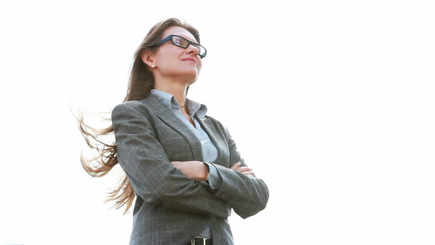 Smiling businesswoman standing in a confident pose, wind blowing her hair