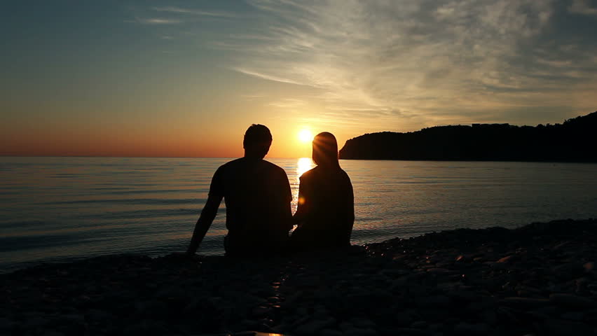 Couple on the shore of the sea, Romantic Couple at Sunset. Two people in love at sunset. Man and woman on the beach