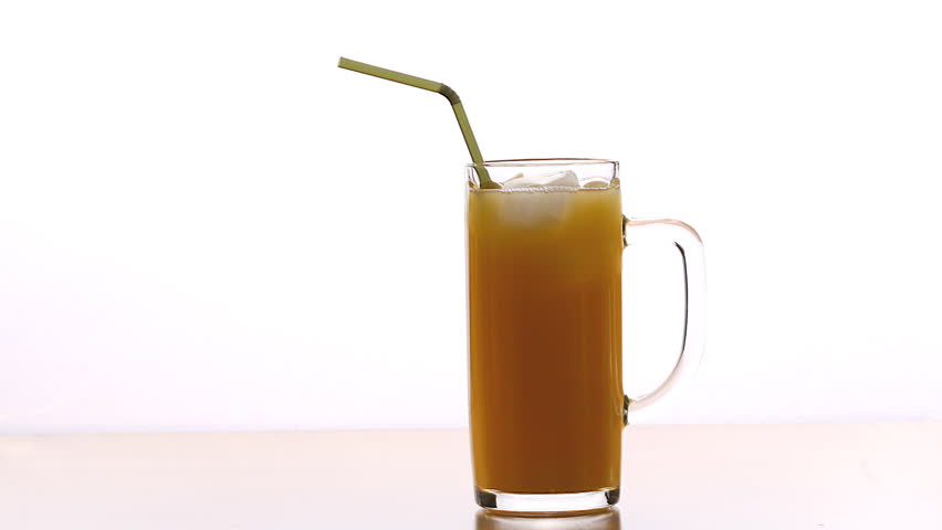 timelapse: juice in a glass with ice and one straw