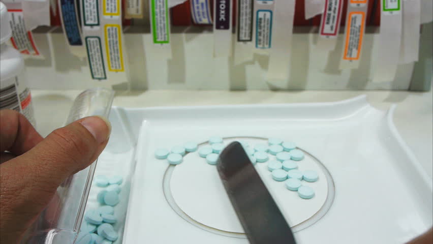 a pharmacist counts pills
