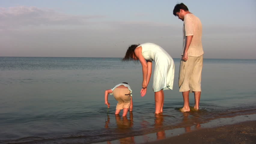 family with boy searching shells 