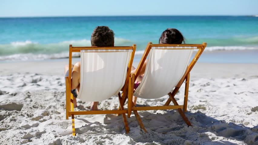 Relaxed couple looking out at the sea on the beach