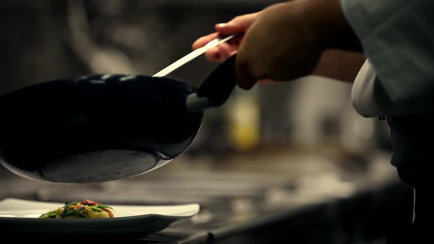 Chef prepares a dish in a restaurant kitchen