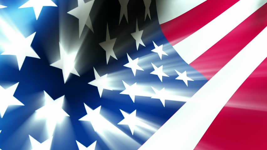 American Flag 0112 - The American flag waves in the breeze as light rays shoot from the stars.