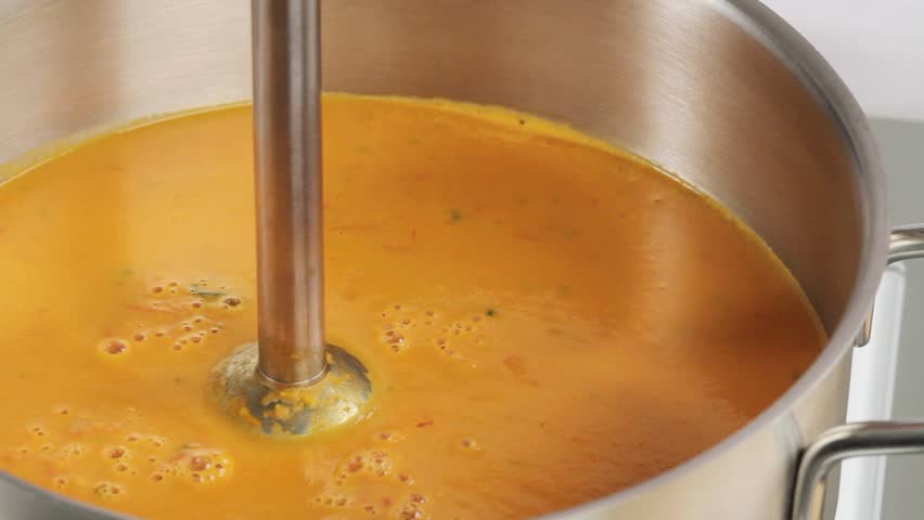 Pureeing tomato soup with a hand blender