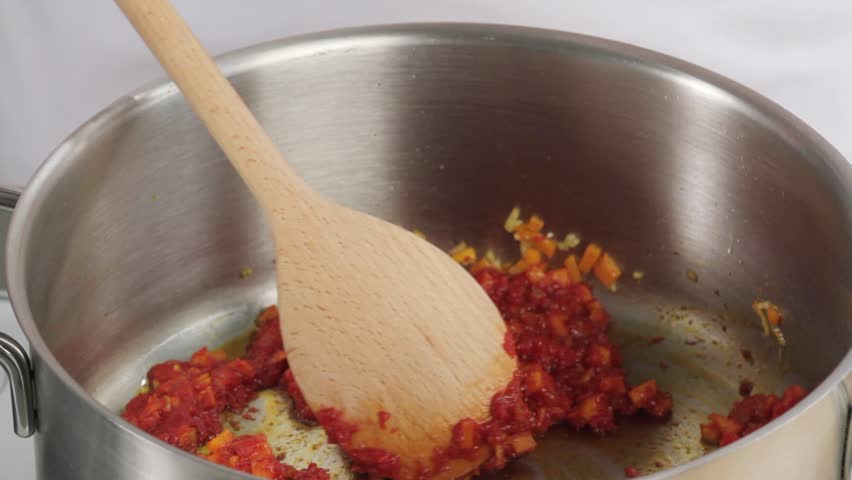 Placing cherry tomatoes in a saucepan