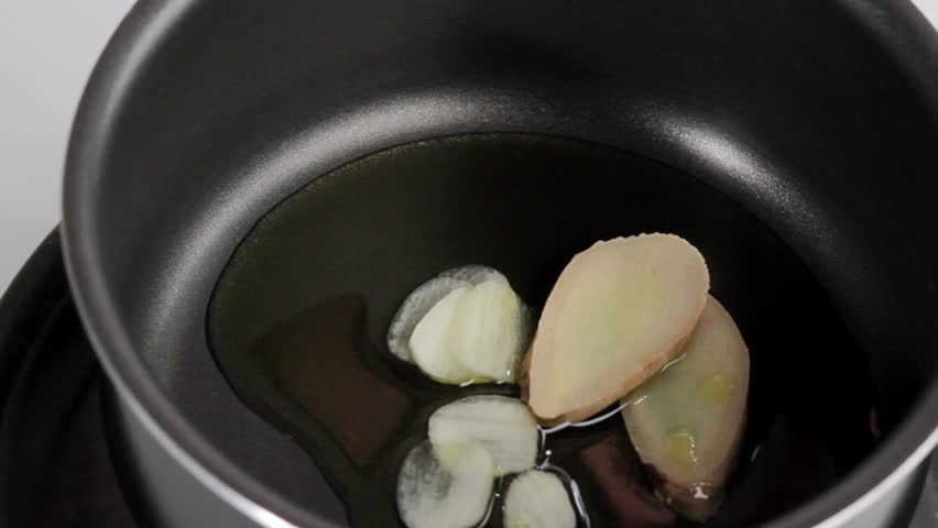 Placing lemon zest and chilli rings in a saucepan