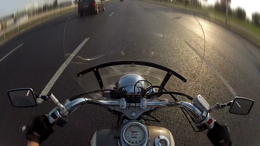 Biker driving the motorcycle on city highway, POV
