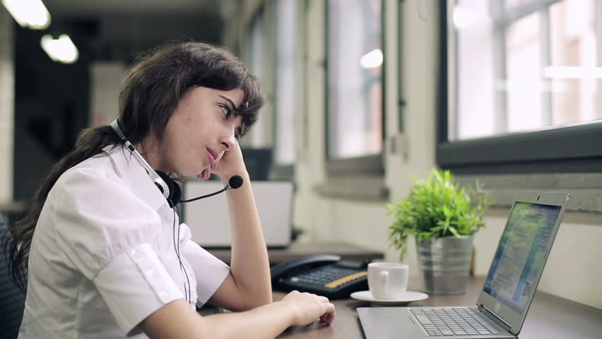 Tired, overworked female helpdesk consultant in the office
