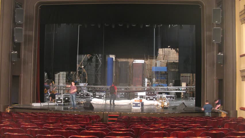 Stagehands dismantle scenery after performance in theatre, time lapse