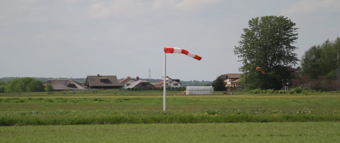 Windsock at the airport in Latvia. Wind blowing away from the camera, and to the right.