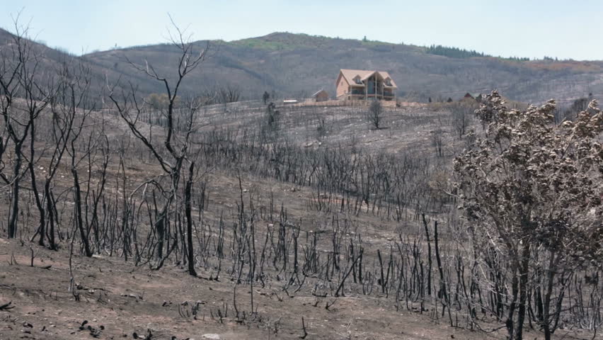 INDIANOLA, SANPETE, UTAH 3 JUL 2012: Luxury house survived mountain wildfire. Forest wildfire intense flames, smoke and destruction. Charred burnt homes and business. Destructive. Wood Hollow Utah.