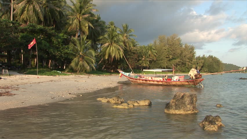 Ko Samui, Thailand - CIRCA December, 2006: A boat docked on the shore and the captain walks to it