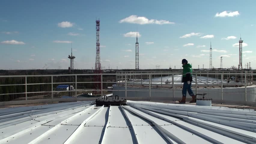 Worker on a top of a huge oil tank