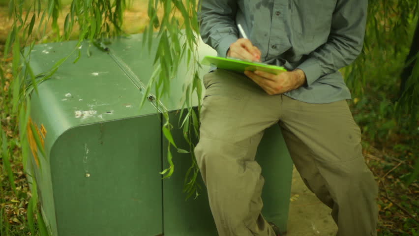 An electrician taking notes on an electric box