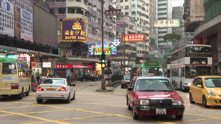Hong Kong, China - CIRCA April, 2007: Busy street scene with many buses and cars as well as lots of neon signs during the day
