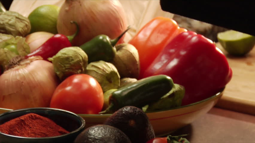 vignette of pans over mexican vegetables, serving and garnishing guacamole