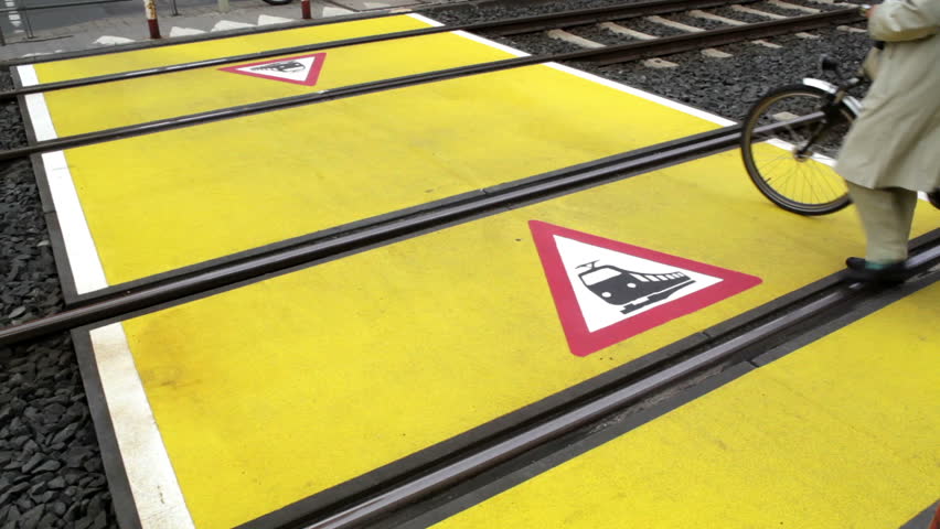 Unrecognizable person walks over the railroad crossing