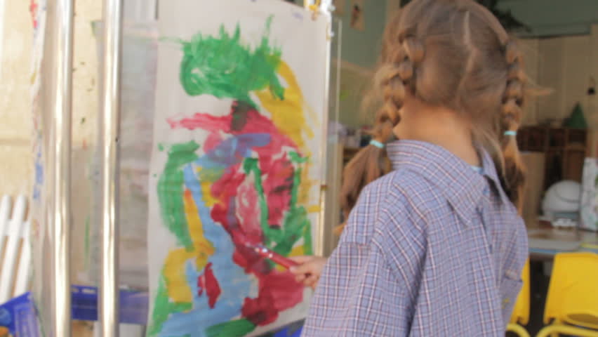 Little girl painting a picture in preschool