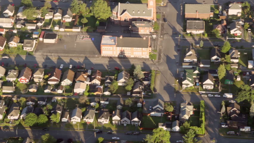 Aerial view from low-flying airplane of suburban neighborhood street and residential blocks