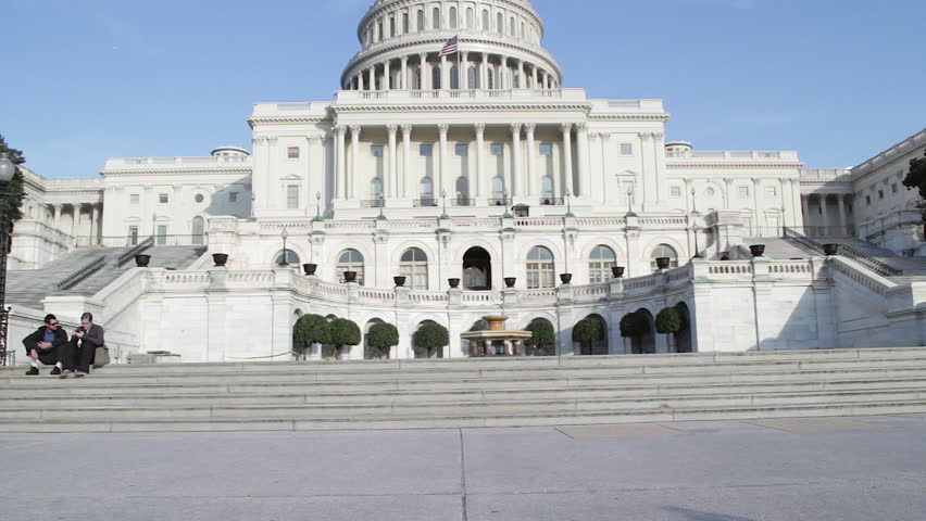Washington DC, USA - October 23: United States Capitol in Washington DC, USA, home of Congress, the House of Representatives and the US Senate. Tilt shot, tourists sit on the steps.