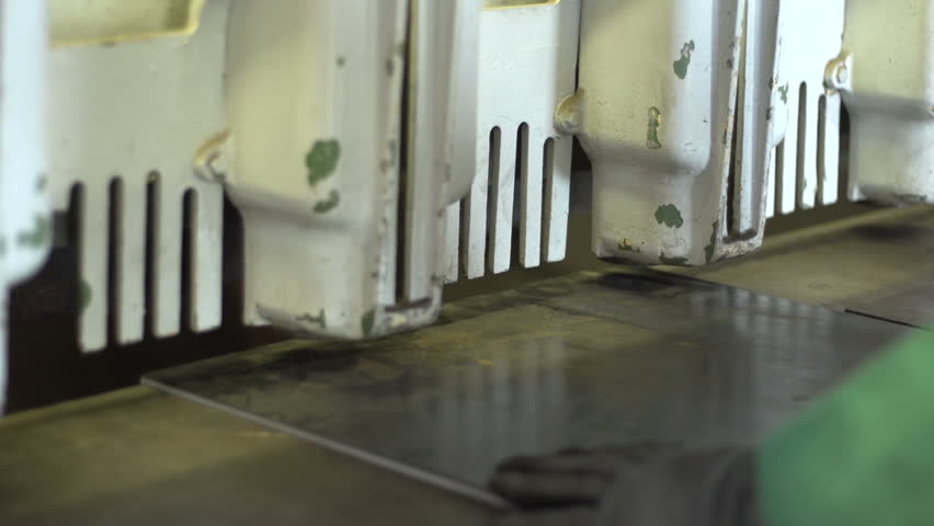 Man cutting steel plate on a shear