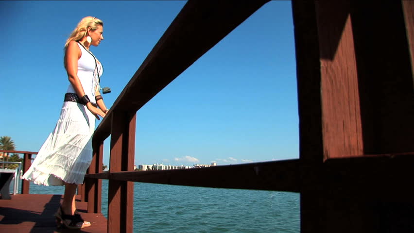 Beautiful elegant blonde gazes out over the water
