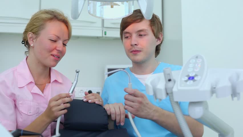 Doctor speaks with her assistant about dental procedures and they imitate it by tools