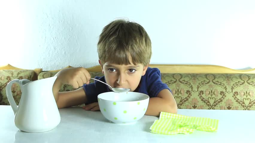 Boy eats granola with milk