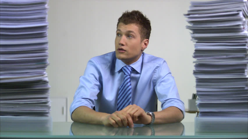 A man with two piles of paper beside him, decreasing and increasing