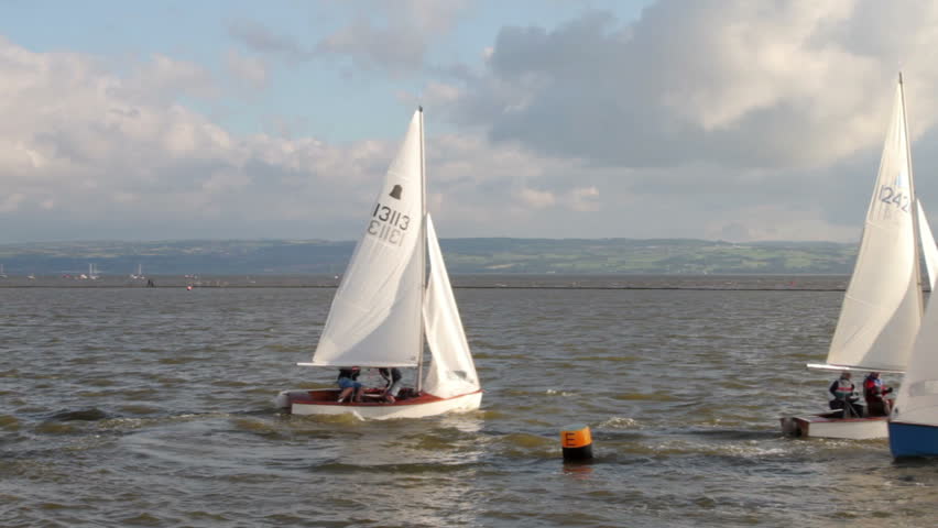 WIRRAL, CHESHIRE/ENGLAND - JUNE 12: Sailing dinghies tack round a buoy on West Kirby Marine Lake on June 28, 2012 in Wirral. The Marine Lake is a man made coastal lake fed by the sea at high tide.
