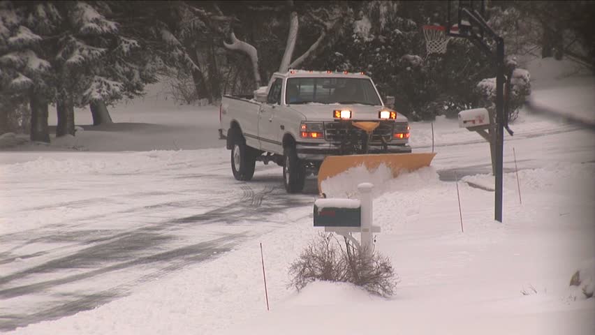 Snow plow plowing residential street