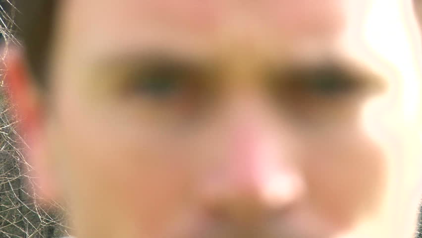 Angry man appears, stares down camera and moves out of frame.